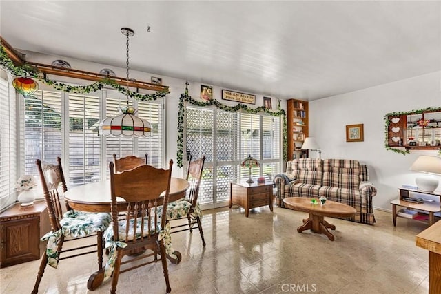 dining room featuring a healthy amount of sunlight and baseboards