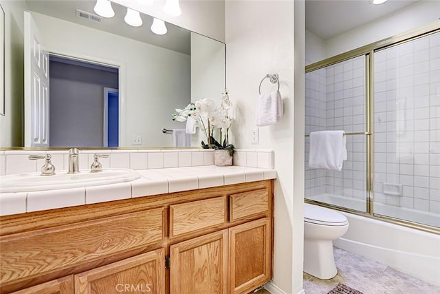 full bathroom featuring tile patterned flooring, visible vents, bath / shower combo with glass door, toilet, and vanity