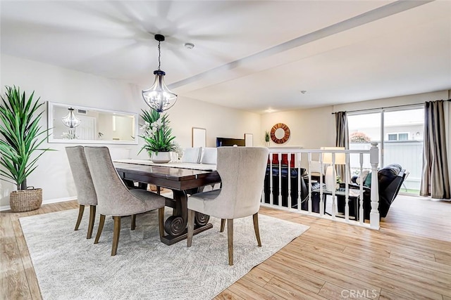 dining area with a notable chandelier, baseboards, and light wood-type flooring