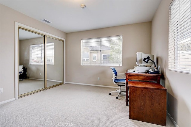 carpeted office space featuring visible vents and baseboards