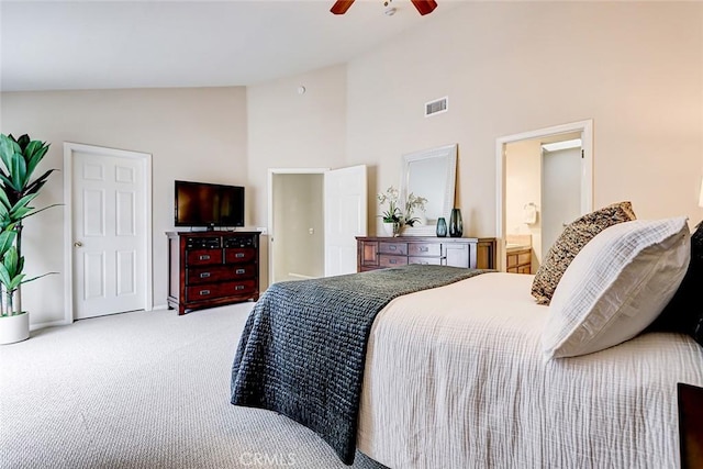 bedroom featuring visible vents, light carpet, high vaulted ceiling, connected bathroom, and ceiling fan