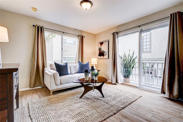 living area featuring light wood-type flooring and baseboards