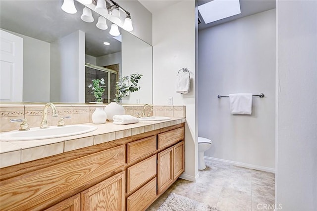 full bath with a shower stall, a skylight, double vanity, and a sink