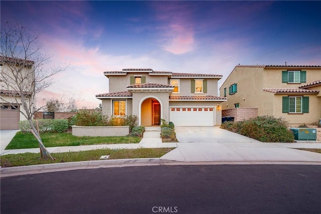 mediterranean / spanish home with stucco siding, central AC, concrete driveway, a garage, and a tiled roof