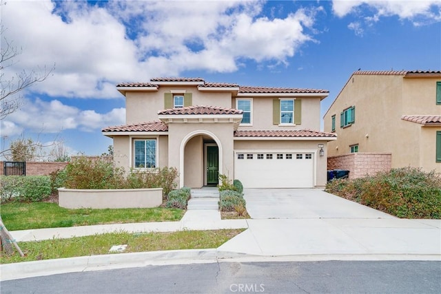 mediterranean / spanish home featuring stucco siding, an attached garage, driveway, and fence