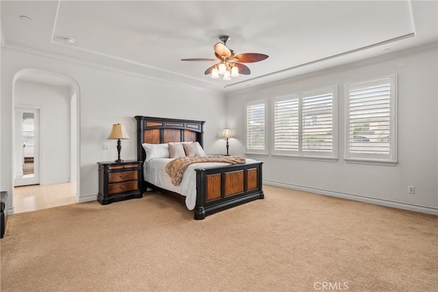 carpeted bedroom with arched walkways, a ceiling fan, crown molding, and baseboards