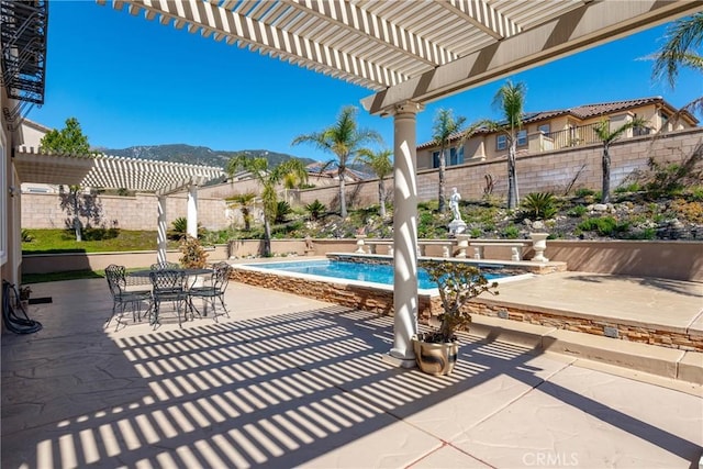 view of patio / terrace featuring a mountain view, a fenced backyard, and a pergola