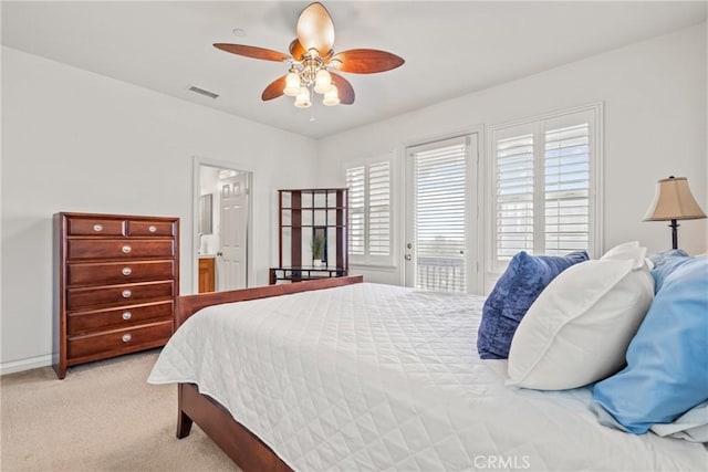 bedroom with visible vents, light carpet, ensuite bathroom, a ceiling fan, and access to outside