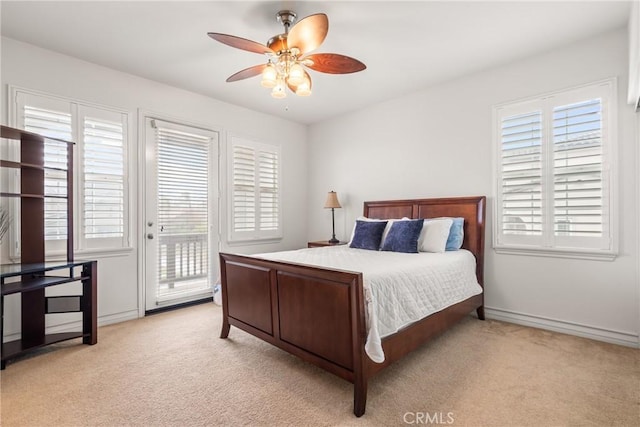 carpeted bedroom featuring ceiling fan, baseboards, multiple windows, and access to exterior