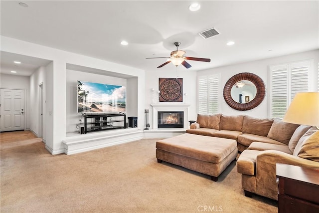 living area featuring visible vents, carpet, recessed lighting, a glass covered fireplace, and a ceiling fan