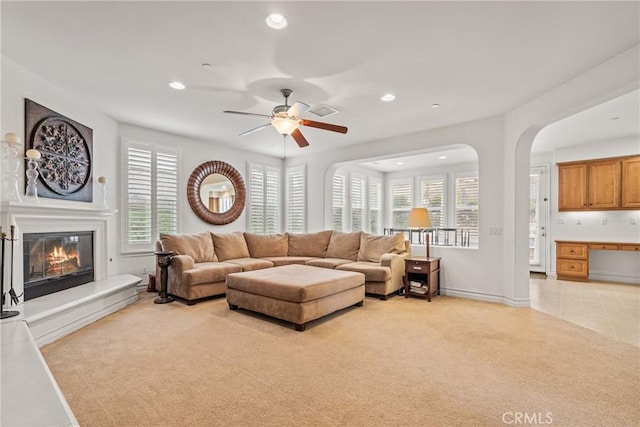 living room with ceiling fan, light colored carpet, light tile patterned floors, recessed lighting, and a glass covered fireplace