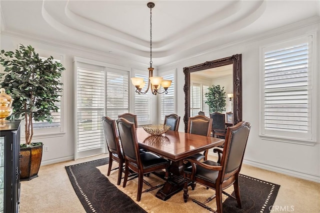 dining room with an inviting chandelier, light colored carpet, and a tray ceiling