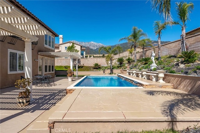 view of swimming pool with a fenced in pool, a fenced backyard, a mountain view, a pergola, and a patio