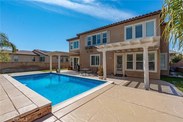 back of property featuring fence, a tiled roof, stucco siding, a pergola, and a patio