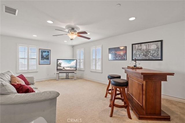 living area featuring recessed lighting, visible vents, light carpet, and ceiling fan