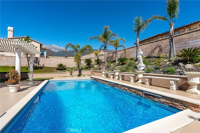 view of swimming pool with a fenced in pool, a mountain view, a pergola, and a fenced backyard