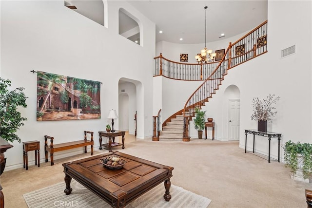 living room with an inviting chandelier, carpet flooring, visible vents, and arched walkways