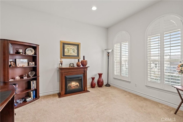 sitting room featuring a glass covered fireplace, carpet flooring, recessed lighting, and baseboards