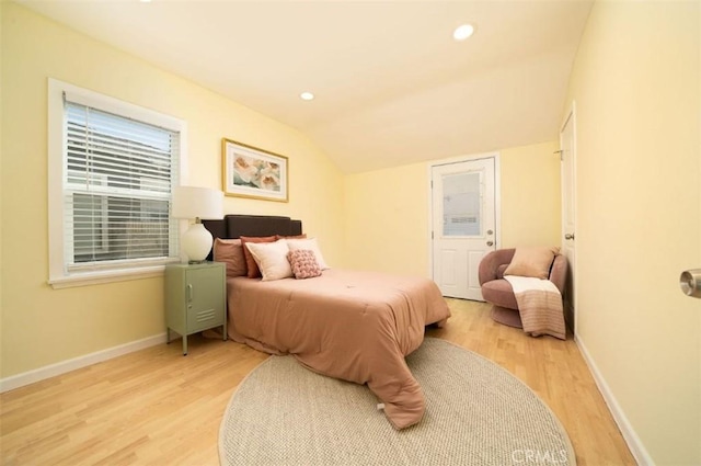 bedroom featuring baseboards, lofted ceiling, and wood finished floors