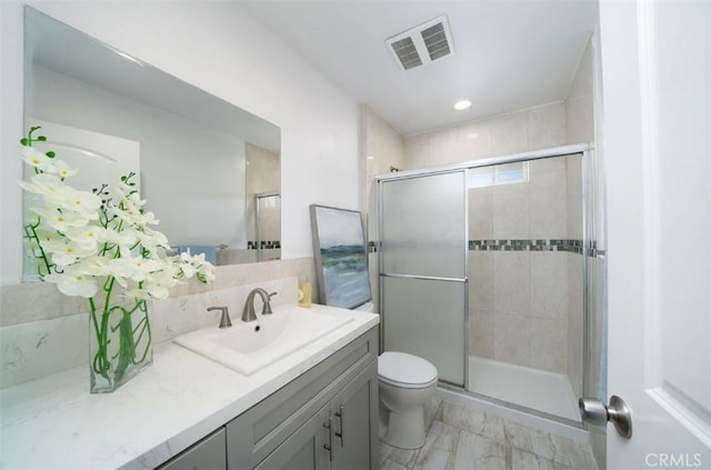 bathroom with visible vents, toilet, tasteful backsplash, a shower stall, and vanity