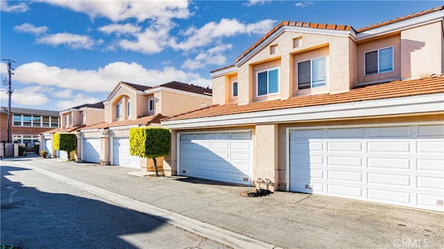 view of front of house featuring a tiled roof, a residential view, and stucco siding