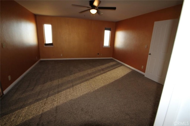 carpeted empty room featuring baseboards and a ceiling fan