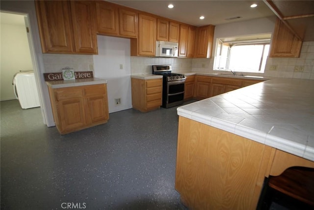 kitchen with brown cabinets, double oven range, recessed lighting, white microwave, and tile counters