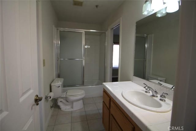 full bathroom with bath / shower combo with glass door, toilet, vanity, and tile patterned flooring