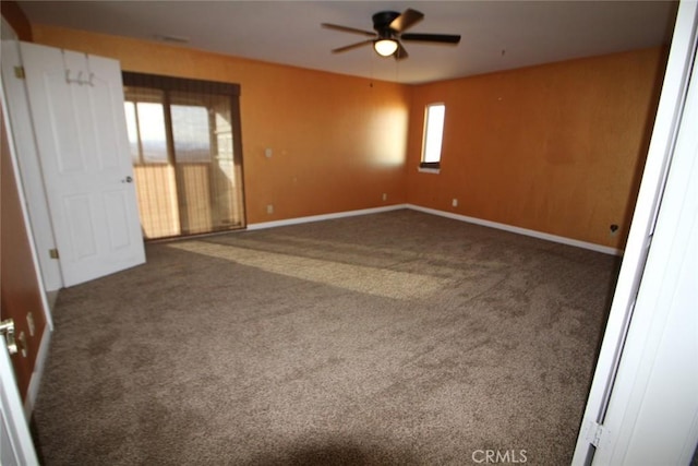 carpeted empty room featuring baseboards and a ceiling fan