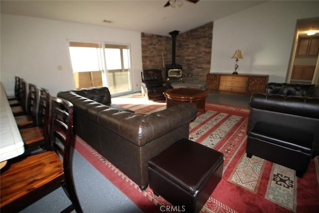 living room with lofted ceiling and a wood stove