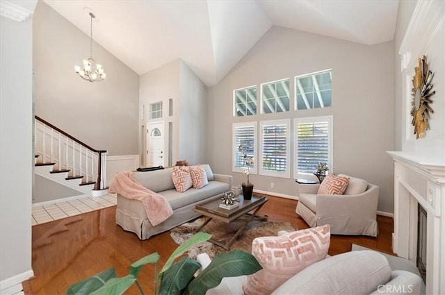 43966 Highlander Dr, Temecula, CA 92592 - living room with wood finished floors, stairs, high vaulted ceiling, a chandelier, and baseboards