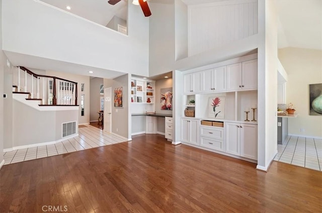 43966 Highlander Dr, Temecula, CA 92592 - unfurnished living room with hardwood / wood-style flooring, high vaulted ceiling, a ceiling fan, baseboards, and stairs