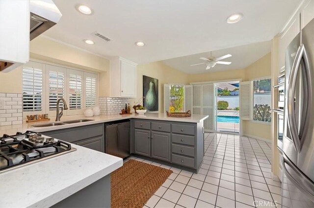 43966 Highlander Dr, Temecula, CA 92592 - kitchen with gray cabinets, appliances with stainless steel finishes, a sink, a peninsula, and light countertops