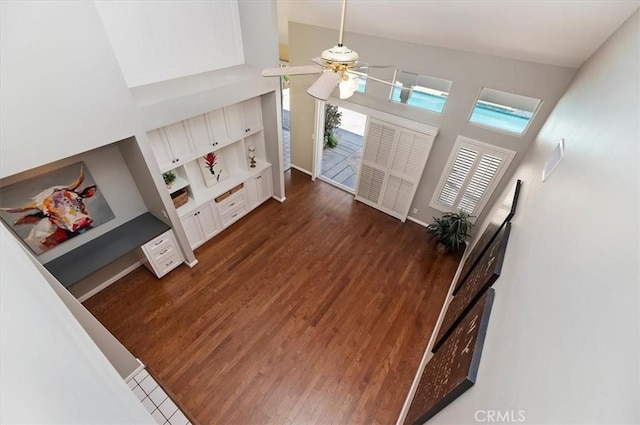 43966 Highlander Dr, Temecula, CA 92592 - unfurnished living room with a towering ceiling, dark wood-type flooring, ceiling fan, and baseboards