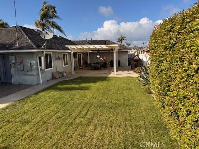 back of property featuring a patio, a lawn, and fence