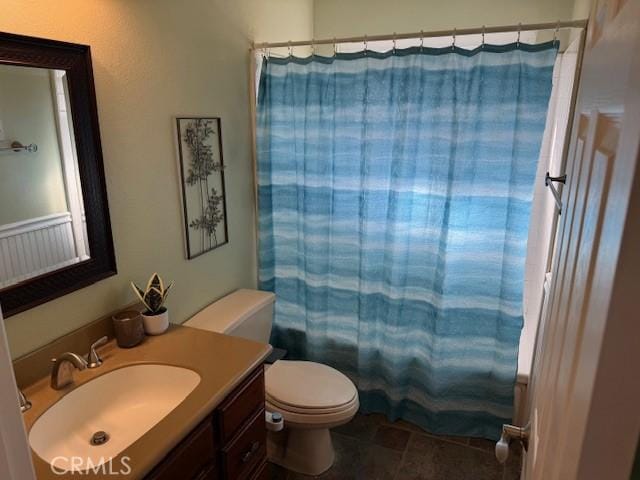 bathroom featuring a shower with shower curtain, toilet, and vanity