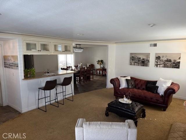 carpeted living room with visible vents, crown molding, and baseboards