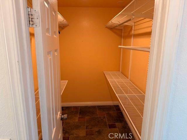 walk in closet with stone finish floor