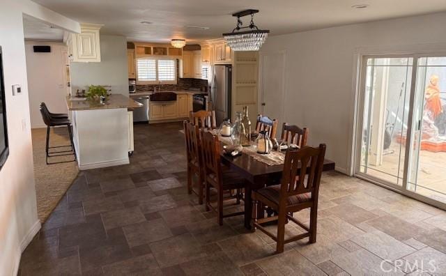 dining room featuring stone finish floor and baseboards