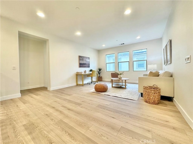 living room with recessed lighting, light wood-type flooring, and baseboards