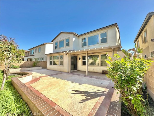 back of property with a fenced backyard, stucco siding, and a patio