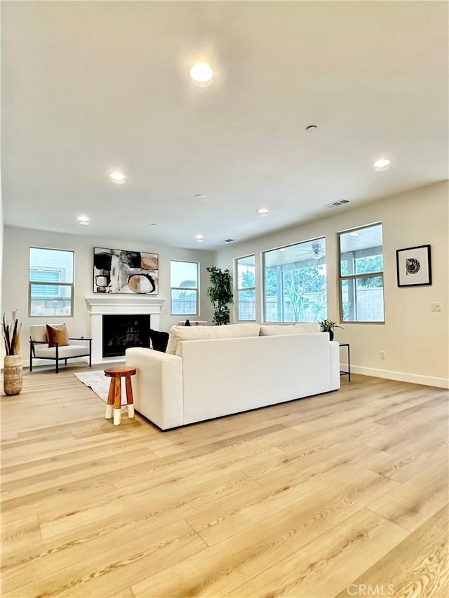 living area with recessed lighting, light wood-style flooring, a fireplace, and visible vents