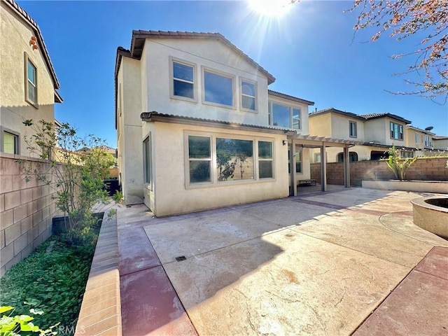 back of house with stucco siding, a patio, a fenced backyard, and a pergola