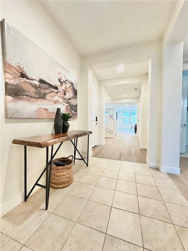 corridor featuring baseboards and tile patterned flooring