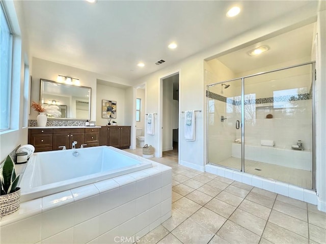 bathroom featuring visible vents, toilet, a shower stall, a bath, and vanity