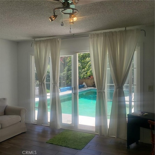 doorway to outside featuring hardwood / wood-style flooring and a textured ceiling