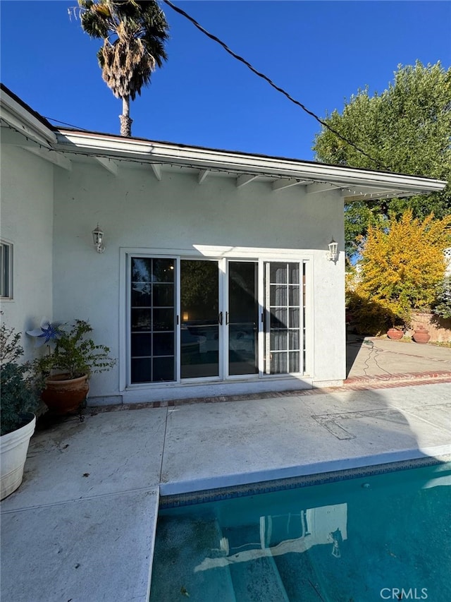 exterior space featuring a pool and stucco siding