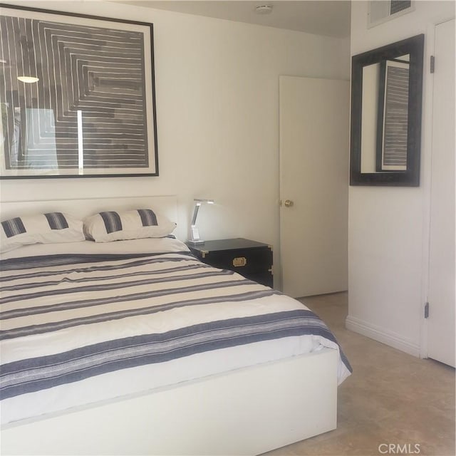 bedroom with baseboards and visible vents