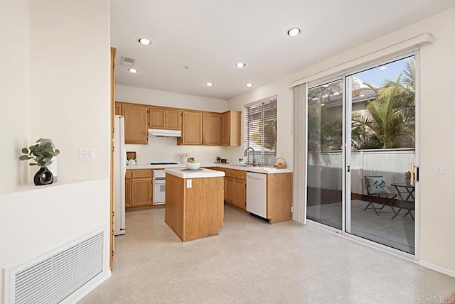 kitchen with white appliances, visible vents, a sink, light countertops, and under cabinet range hood