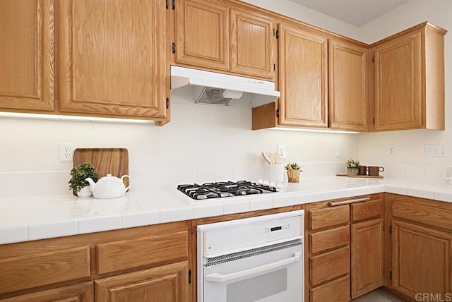 kitchen featuring white appliances and under cabinet range hood